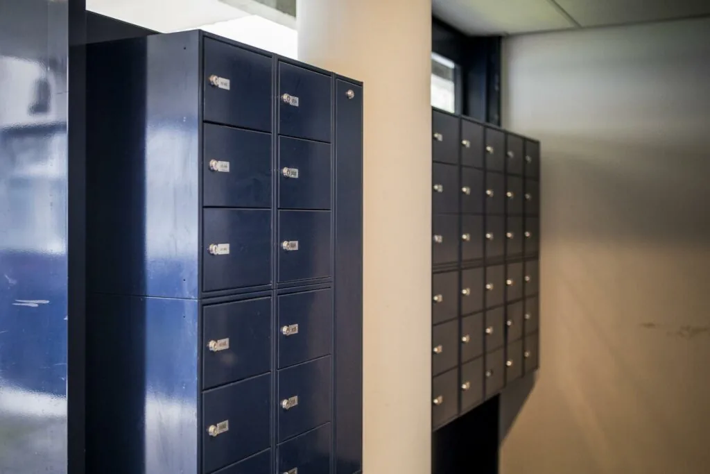 Donkerblauwe postvakkenwand in een modern gebouw aan de Markerkant.